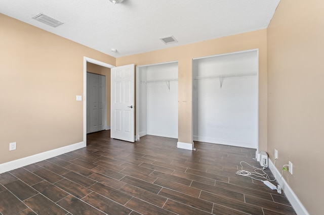 unfurnished bedroom featuring a textured ceiling and dark hardwood / wood-style floors