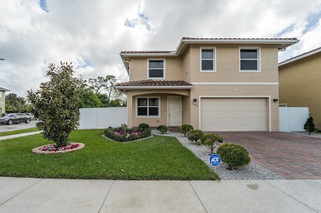 mediterranean / spanish house featuring a garage and a front yard