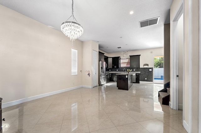 interior space featuring sink, a chandelier, and a textured ceiling