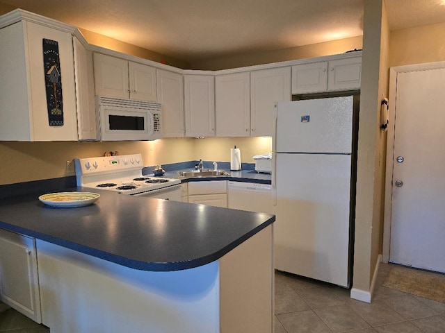 2400 S Ocean Dr Unit 1224, Fort Pierce, FL 34949 - kitchen featuring white appliances, a sink, dark countertops, tile patterned floors, and a peninsula