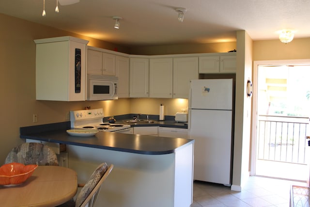 2400 S Ocean Dr Unit 1224, Fort Pierce, FL 34949 - kitchen with white appliances, a sink, a peninsula, and dark countertops