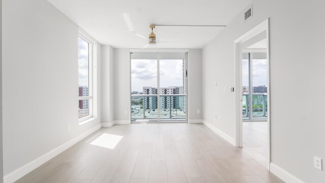 living room featuring floor to ceiling windows, a wealth of natural light, and ceiling fan