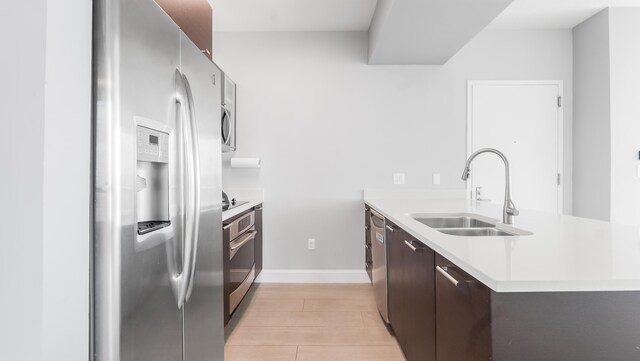 kitchen featuring kitchen peninsula, stainless steel fridge with ice dispenser, a kitchen bar, and sink