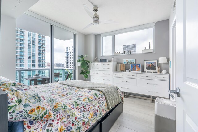 bedroom featuring access to exterior, ceiling fan, and floor to ceiling windows