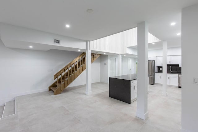 basement featuring stainless steel refrigerator