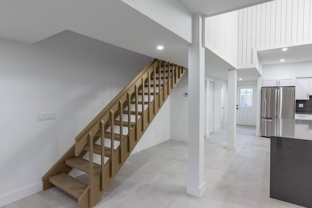 staircase featuring a towering ceiling