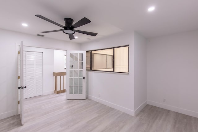 empty room featuring french doors, light hardwood / wood-style flooring, and ceiling fan