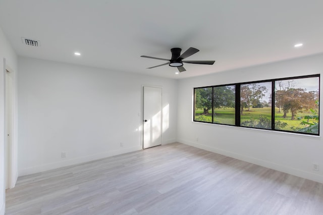 empty room with ceiling fan and light hardwood / wood-style floors