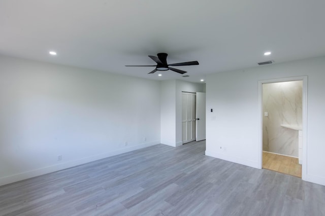 empty room with ceiling fan and light hardwood / wood-style flooring