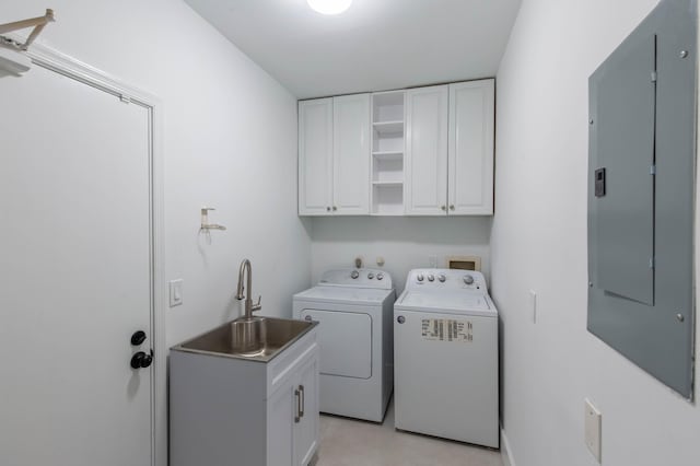 washroom featuring cabinets, electric panel, washer and clothes dryer, and sink