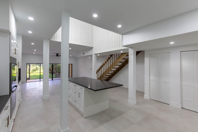 kitchen featuring white cabinets, a towering ceiling, and ceiling fan