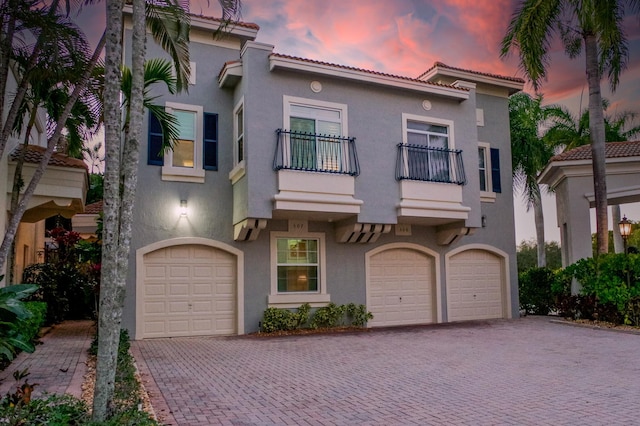 mediterranean / spanish-style house with a balcony and a garage