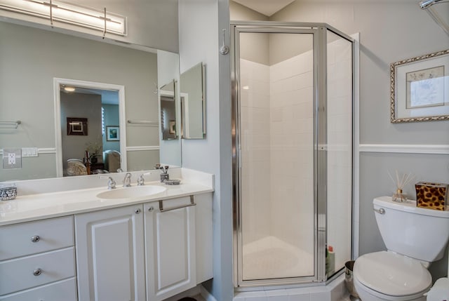 bathroom with vanity, toilet, and a shower with shower door