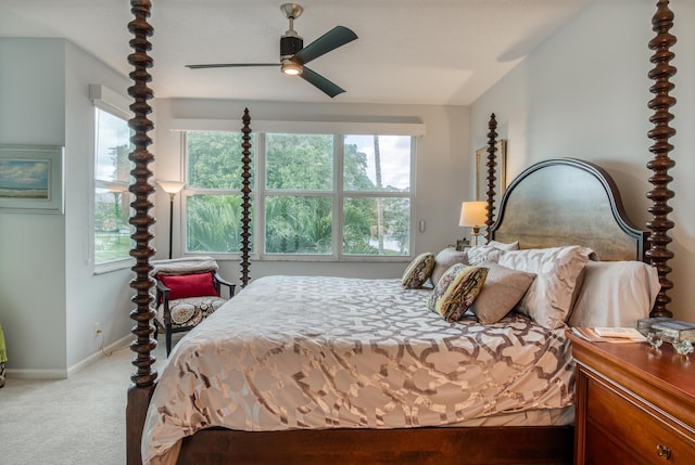 bedroom featuring ceiling fan, light colored carpet, and multiple windows