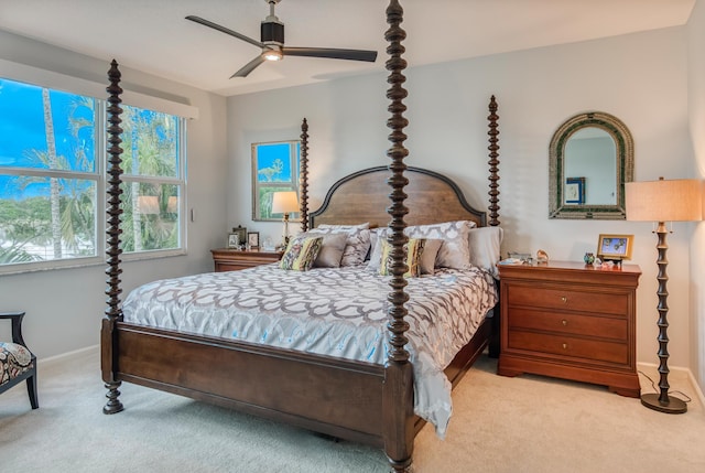 carpeted bedroom featuring multiple windows and ceiling fan