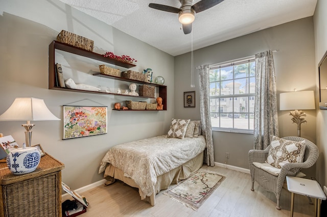 507 Resort Ln, Palm Beach Gardens, FL 33418 - bedroom with multiple windows, wood finished floors, a textured ceiling, and baseboards