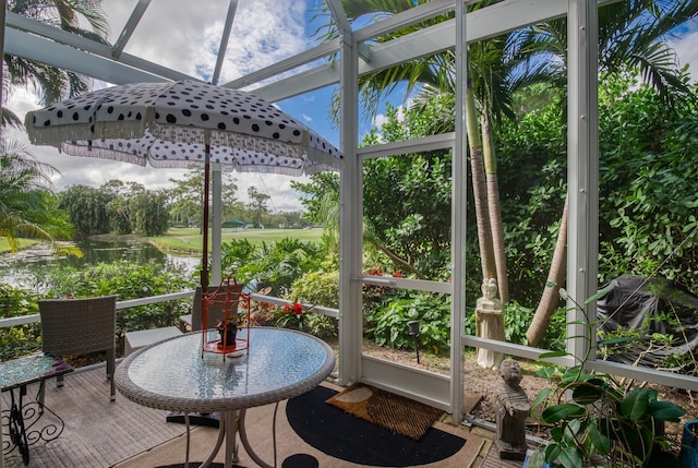 sunroom featuring a water view