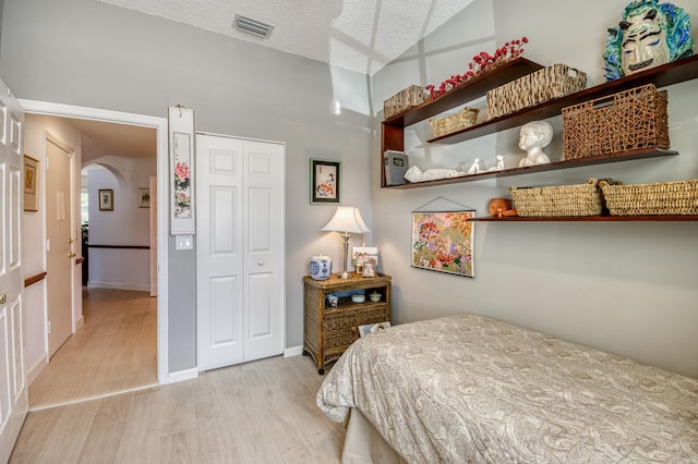 507 Resort Ln, Palm Beach Gardens, FL 33418 - bedroom featuring light wood finished floors, a closet, arched walkways, and baseboards