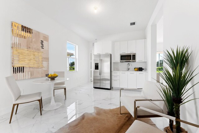 kitchen featuring white cabinets, stainless steel appliances, and sink