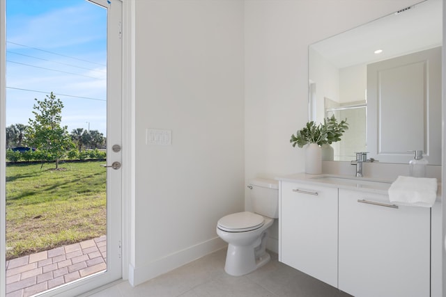 bathroom featuring tile patterned flooring, vanity, toilet, and walk in shower