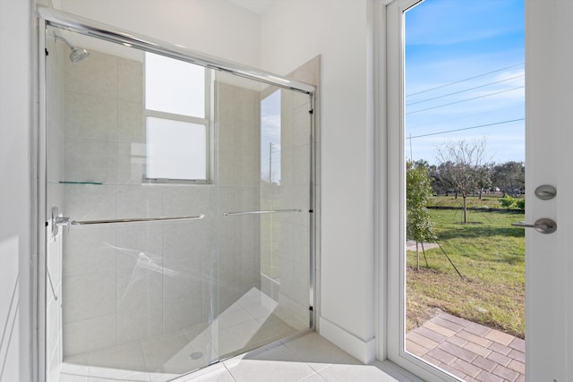 bathroom with a wealth of natural light, tile patterned floors, and walk in shower