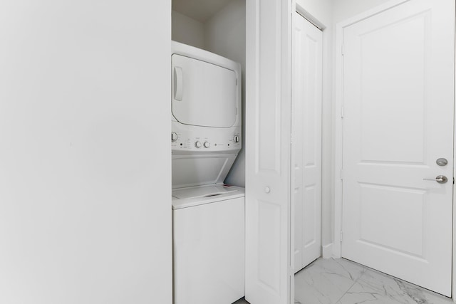 clothes washing area featuring stacked washing maching and dryer