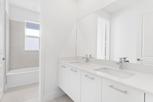 bathroom with tile patterned flooring, vanity, and tiled shower / bath