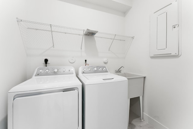 clothes washing area featuring electric panel and washer and clothes dryer