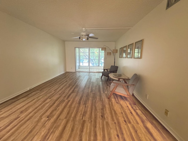 interior space featuring hardwood / wood-style floors, ceiling fan, and a textured ceiling