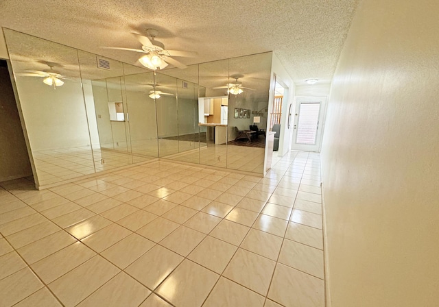 spare room featuring light tile patterned floors and a textured ceiling