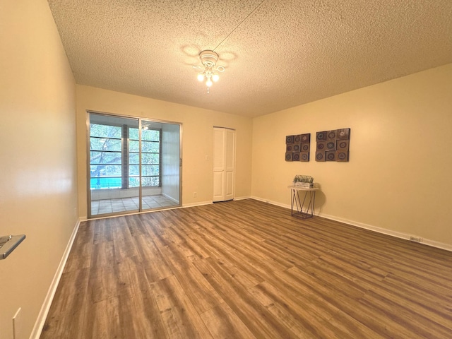 spare room with dark hardwood / wood-style flooring and a textured ceiling