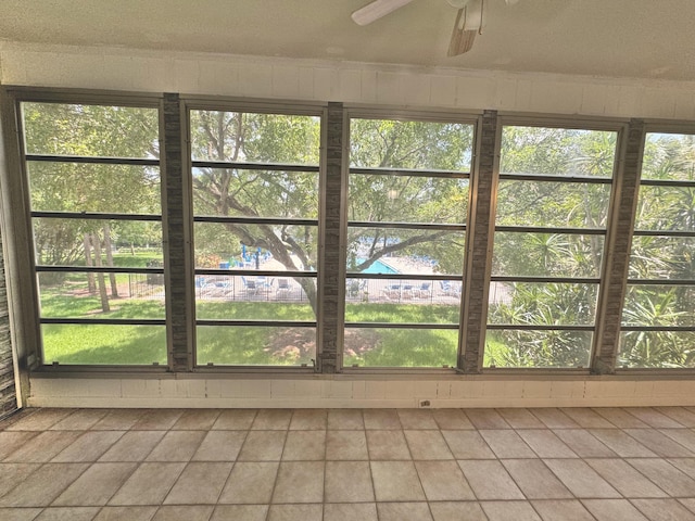 unfurnished sunroom featuring a wealth of natural light and ceiling fan