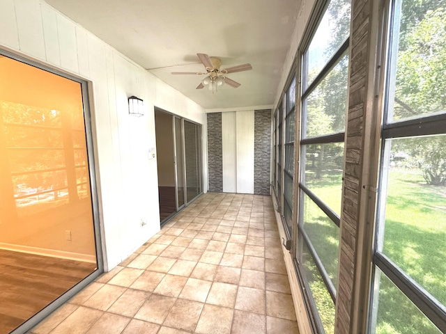 unfurnished sunroom featuring ceiling fan