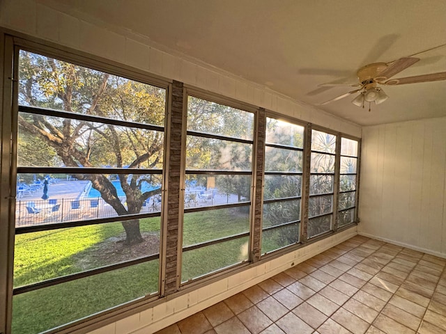 unfurnished sunroom with ceiling fan