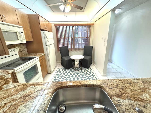 kitchen featuring light tile patterned floors, white appliances, ceiling fan, and sink