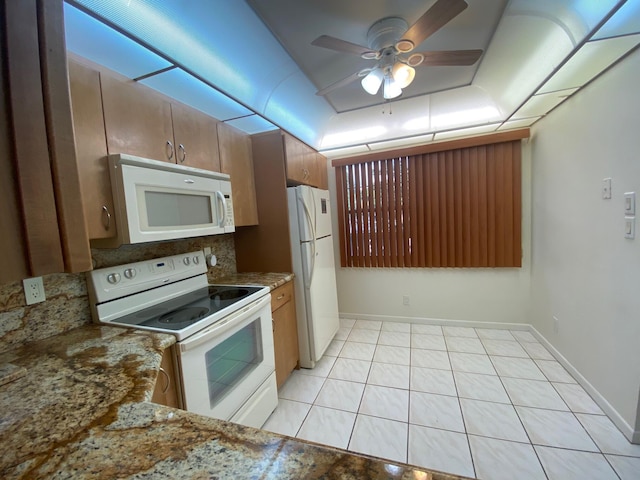 kitchen featuring ceiling fan, light tile patterned floors, light stone counters, and white appliances