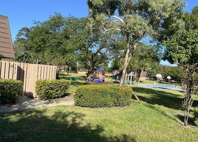 view of yard with a playground and basketball hoop