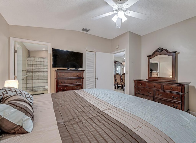 bedroom featuring ceiling fan, a textured ceiling, and ensuite bathroom