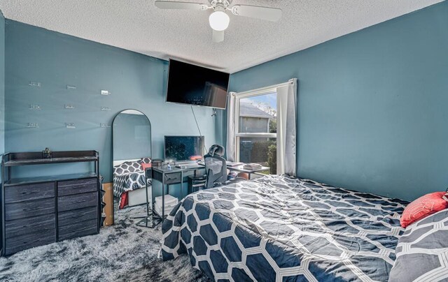 bedroom featuring ceiling fan, light colored carpet, and a textured ceiling