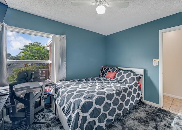 tiled bedroom featuring ceiling fan and a textured ceiling