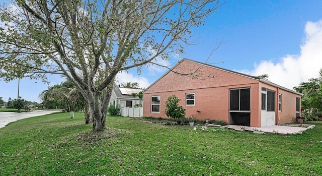 view of property exterior with a yard and a patio area