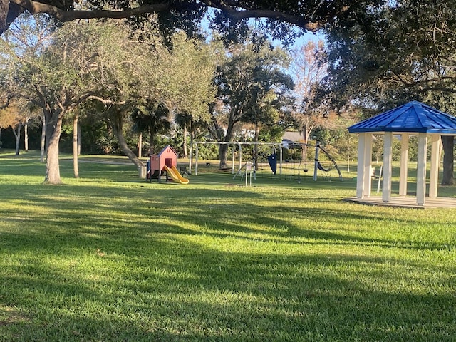 view of property's community featuring a lawn and a playground