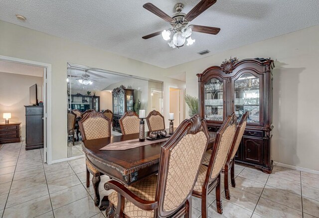 dining area with ceiling fan, light tile patterned floors, and a textured ceiling