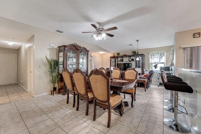 tiled dining room featuring ceiling fan and a textured ceiling