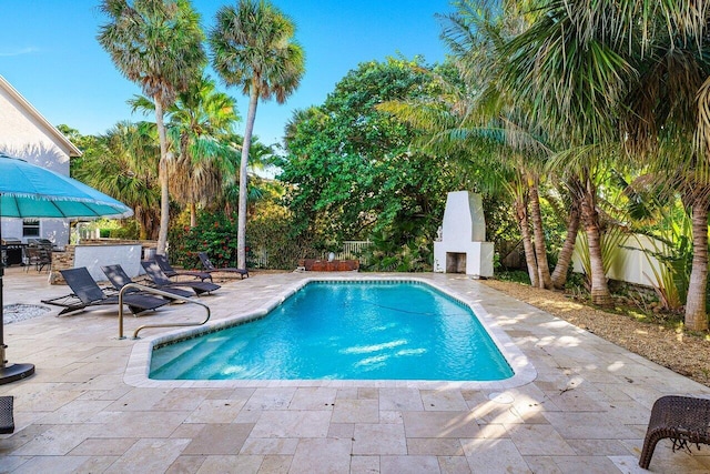 view of pool with a patio area and an outdoor fireplace