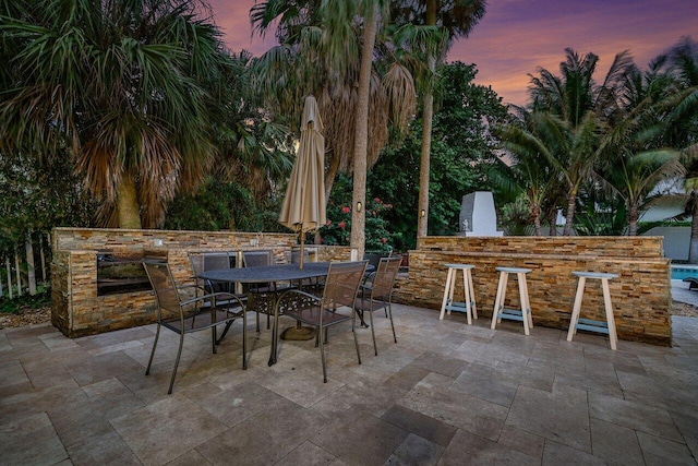 patio terrace at dusk featuring exterior bar