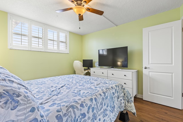 bedroom featuring ceiling fan, dark hardwood / wood-style floors, and a textured ceiling