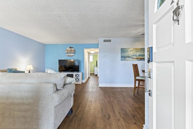 living room featuring a textured ceiling and dark wood-type flooring