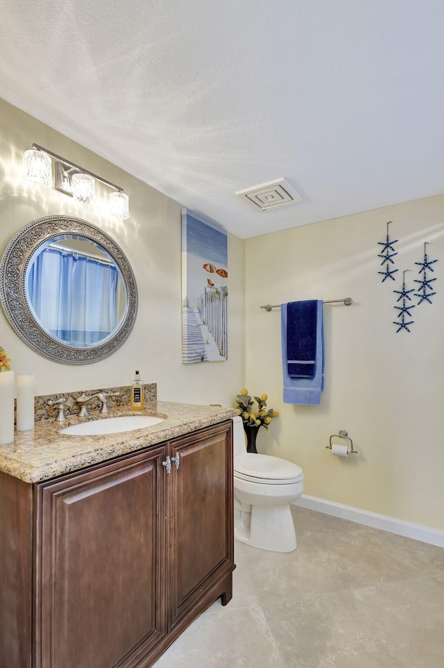 bathroom with vanity, a textured ceiling, and toilet