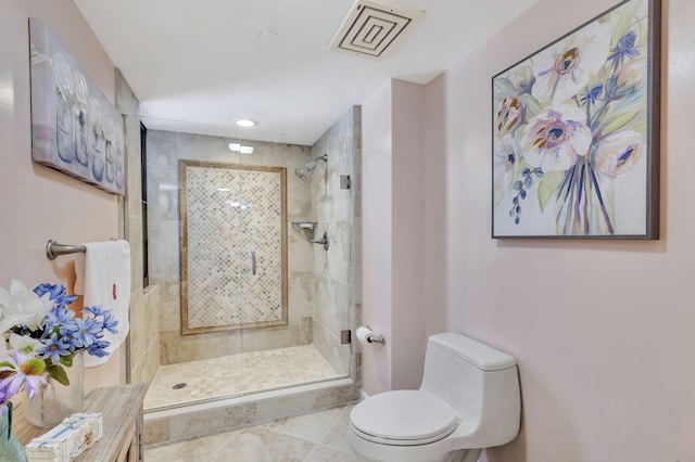 bathroom with tile patterned floors, toilet, and a shower with shower door